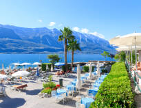 Det tar kun få minutter ned til Gardasjøen, hvor hotellet har en privat strand med solsenger og parasoller.